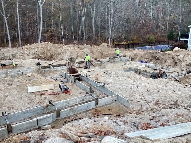Crew setting footing forms for a large house