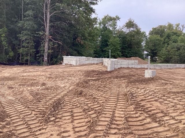 Excavation contractor's job: soil backfilled and graded around a new foundation