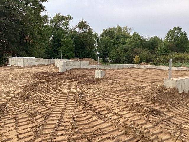 Backfilled house foundation with machine tracks in the graded soil