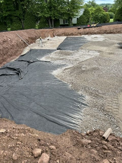 Foundation hole with filter fabric and crushed stone going down for the floor