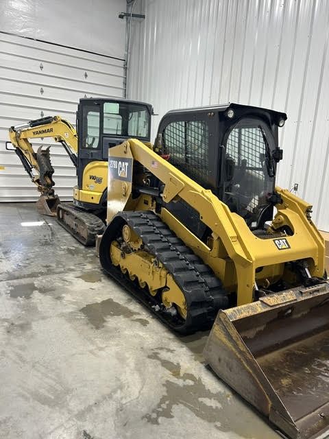 Dig Works tracked skid steer and mini excavator parked in the shop